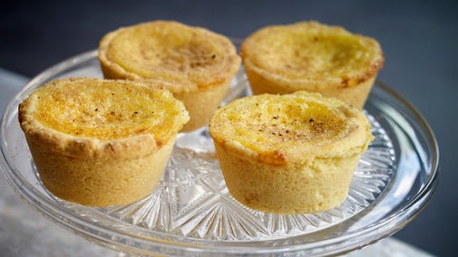 Individual custard tarts on a glass stand